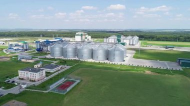 Büyük gümüş ambar. Tahıl deposu. Karışık yem üretimi için bir fabrika. Tarımsal ürünleri işleme fabrikası. Besleme Fabrikası. Sahada modern tarım üretimi. Tahıl tanelerini büyük bir fabrikada depolamak için tahıl asansörleri.  
