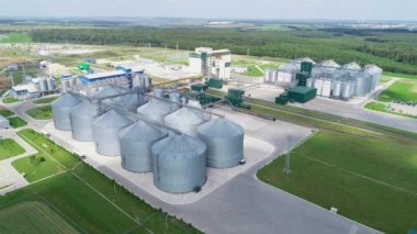 Büyük gümüş ambar. Tahıl deposu. Karışık yem üretimi için bir fabrika. Tarımsal ürünleri işleme fabrikası. Besleme Fabrikası. Sahada modern tarım üretimi. Tahıl tanelerini büyük bir fabrikada depolamak için tahıl asansörleri.  