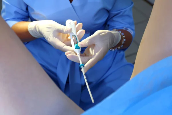 stock image Contraceptive IUD. Installation of a birth control system. The gynecologist installs an IUD. Gynecological chair. An intrauterine contraceptive device with a copper coil used for contraception.