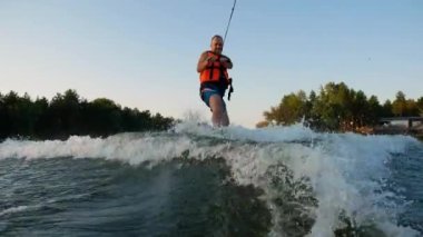 KYIV, UKRAINE, 18 Eylül 2023: Gölde su kayağı. Nehir sporları. Nehirde su işkencesi. Kırmızı can yeleği giyen adam su işkencesi - editörlük görüntüsü