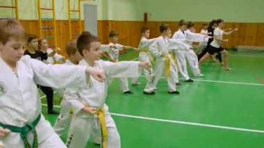 KYIV, UKRAINE - 16 Kasım 2023 Çocuk Tekvandosu. Çocuklar tekvando yarışmasına hazırlanıyor. Çocuk tekvando bölümü. Okul jimnastik salonunun tekvando bölümünde pratik yapan çocuklar - editör görüntüleri