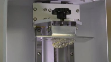 Diş teknisyeni diş kaplaması ve protez kalıpları üzerinde çalışıyor. Diş kliniğinde seramik protez üretimi. İmplantlar için seramik diş başlıkları. 