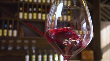 Kırmızı şarap güzel bir bardağa doldurulmuş. Bir barmen bardağa kırmızı şarap döker. Şarap üretimi ve satışı. 
