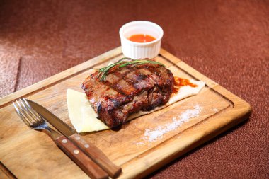 Orta pişmiş biftek mi? Orta pişmiş biftek. Tahta bir tahtanın üzerinde parçalara ayrılmış..