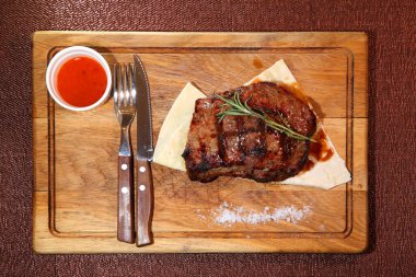 Orta pişmiş biftek mi? Orta pişmiş biftek. Tahta bir tahtanın üzerinde parçalara ayrılmış..