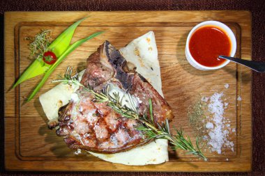 Orta pişmiş biftek mi? Orta pişmiş biftek. Tahta bir tahtanın üzerinde parçalara ayrılmış..