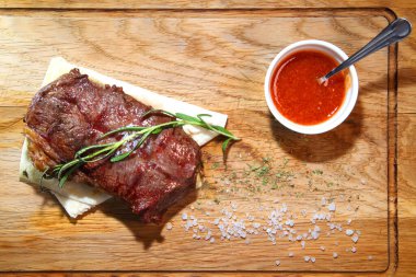 Orta pişmiş biftek mi? Orta pişmiş biftek. Tahta bir tahtanın üzerinde parçalara ayrılmış..