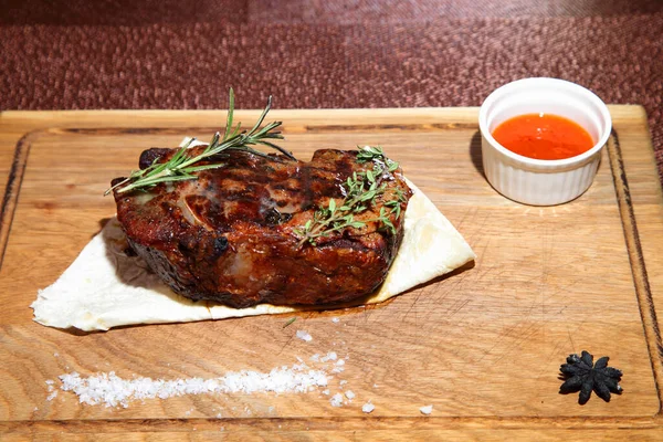 Medium-roasted steak. Medium-roasted steak cut into pieces on a wooden board.