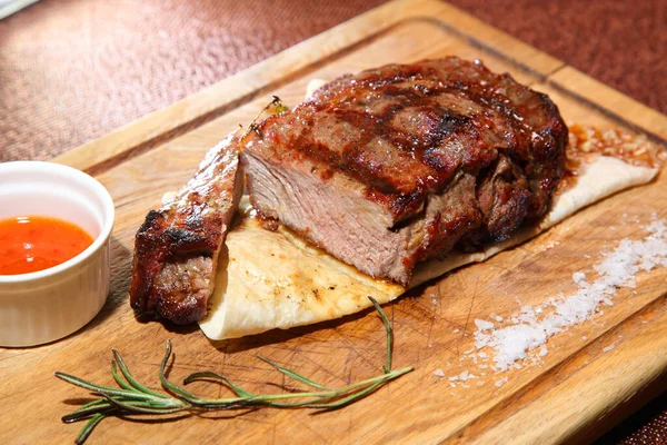 Medium-roasted steak. Medium-roasted steak cut into pieces on a wooden board.