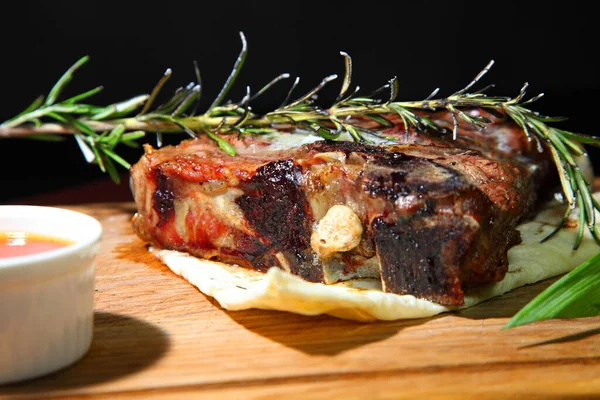 Medium-roasted. Medium-roasted steak cut into pieces on a wooden board.