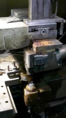 Turner 'lar ve değirmenciler makinelerde çalışır. Makineler parçaları çıkarıyor. Fabrikadaki bir atölyede torna makinesi değirmeni ve torna makinesi. Dikey video.