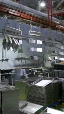 Taşıyıcı hat boyası. Fabrikadaki boyacı. Damgalı parçalar boyanıyor. Metal ürünlerin damgalı parçaları fabrikada boyanır. Dikey video.