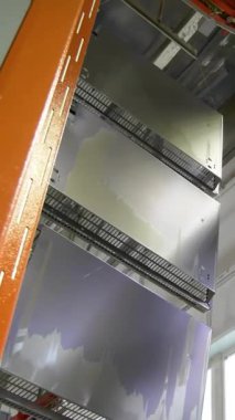 Taşıyıcı hat boyası. Fabrikadaki boyacı. Damgalı parçalar boyanıyor. Metal ürünlerin damgalı parçaları fabrikada boyanır. Dikey video.