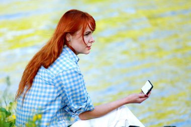 Nehir kenarında tatil. Güzel bir yaz gününde nehir boyunca gezinen bir kız. Neşe, mutluluk, Kız nehri görüyor. dinginlik.