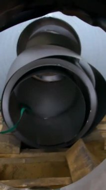 Fabrikadaki ürünlerin basın tarafından oluşturulması için çelik rulolar. Bobinli çelik çarşaf. Dikey video.