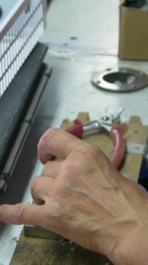 Elektrik ısıtıcılarının fabrika montajı. Taşıyıcı montajı elle yapıyor. Elle montaj taşıyıcısı. Dikey video.  