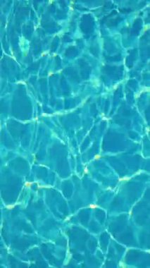 İnanılmaz ve güzel kristal berrak mavi su. Güneşin parlaklığı suya yansıtılır. Kamera merceğinin yarattığı güzel güneş yansıma efekti. Dikey video.