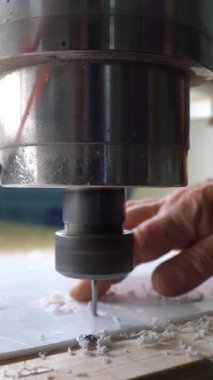 Video seti: Değirmen makinası operatörü plastikten harfler kesiyor. Değirmen makinesi. Bir değirmen makinesi plastik bir çarşaftan harfleri kesiyor. Dikey video.