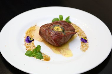 Beyaz tabakta biftek. Biftek mükemmeldi. Orta pişmiş biftek, güzel servis edilmiş beyaz bir tabakta..