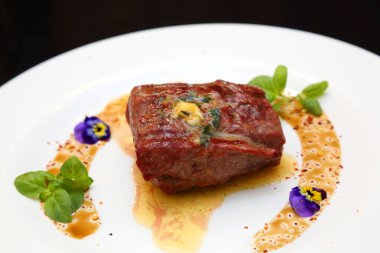 Beyaz tabakta biftek. Biftek mükemmeldi. Orta pişmiş biftek, güzel servis edilmiş beyaz bir tabakta..