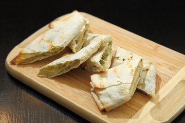 Lavaş ve fırında peynir. Ahşap bir tahtanın üzerinde fırında peynirli lavaş. Peynirli lavaş.