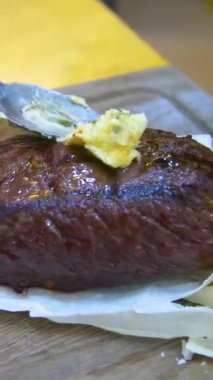 Özel ahşap bir tahtanın üzerindeki pide ekmeğine orta pişmiş biftek. Tahtada biftek var. Dikey video.