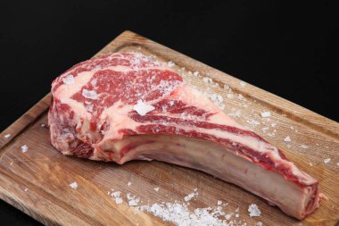 Çiğ biftek. Tahtada pişmeyi bekleyen çiğ, yıllanmış bir biftek..