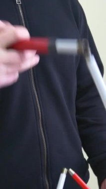 Vinnytsia, Ukrayna - 25 Ocak 2025: Körlerin ameliyat sonrası adaptasyonu. Kör askerlerin adaptasyonu. Kör bir savaş gazisi bastonla hareket eder. Dikey video.