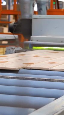 Plastik üretim için endüstriyel ekipmanlar. Parke tahtası ve lamine üretim hattı. Yerleri cilalayın. Laminate üretim tesisi. Dikey video.
