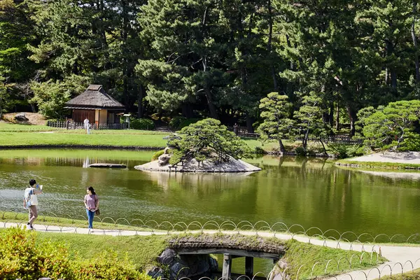stock image OKAYAMA, JAPAN - MAY 22 2023: Visitors enjoying a leisurely walk through the beautiful Korakuen Garden, a popular tourist spot in Okayama, Japan. 