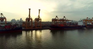 Güneş doğduğunda Bangkok Limanı 'nda konteynır gemilerinin 4k drone' u ve vinçleri kaldırıyor. 2018-07-24 Tayland.