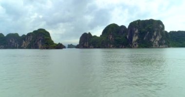 4k Aerial Karst dağlarıyla kenetlenmiş teknelerin üzerinde. Ha uzun koy. Halong Şehri, Vietnam