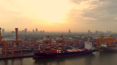 Konteynır gemilerinin İHA 'ları ve gündoğumunda Bangkok Limanı' nda vinçleri kaldıran hava görüntüsü 4k video..