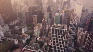 Hong Kong 'daki modern gökdelenlerin 4k hava aracı görüntüsü. Gündoğumunda Hong Kong 'da binalar.