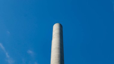 Gökyüzünün arka planında baca var. Duman piposu ve mavi gökyüzü