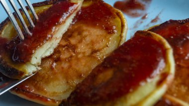 Mavi tabakta krep. Kırmızı soslu gözleme. Bir tabakta çilek reçeli ve krep. Tahta bir masanın üzerinde krep tabağı. Krepli kahvaltı.