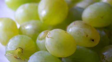 Tabaktaki büyük beyaz üzümleri yakından çek. Beyaz bir tabakta duran beyaz üzümler.