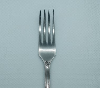 Beyaz arka planda demir çatal yakın plan. Beyaz arka planda gümüş çatal