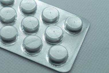 Beyaz arka planda yuvarlak beyaz haplar. Bir tablet beyaz yuvarlak hap.