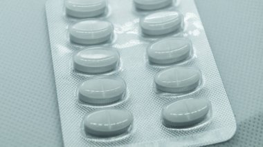 Beyaz arka planda yuvarlak beyaz haplar. Bir tablet beyaz yuvarlak hap.