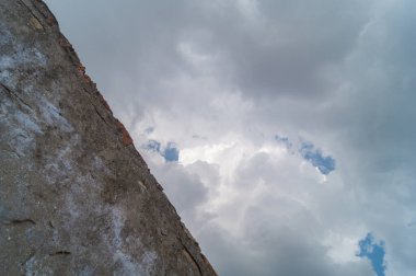 Mavi gökyüzü ve kabarık bulutlar arka planda inşa duvarı ile yağmurdan sonra