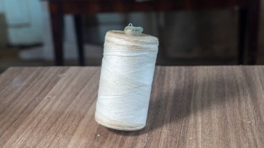 Tahta bir yüzey üzerinde eski beyaz iplikçikler.
