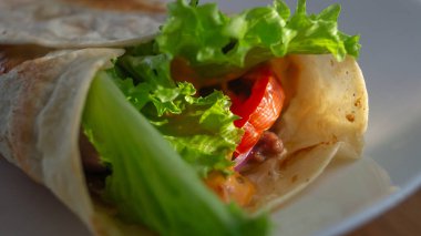 Güneş ışığında beyaz bir tabağa yakın çekim yapan tortilla. Tortilla yemeği yakın plan.