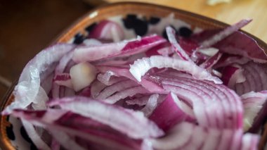 Kırmızı soğan küçük bir kasede yarım halkalara bölünmüş. Yemek pişirmek için gerekli malzemeler