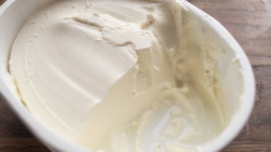 Paketteki krem peynirin yakın plan çekimi. Beyaz krem peynir dokusu
