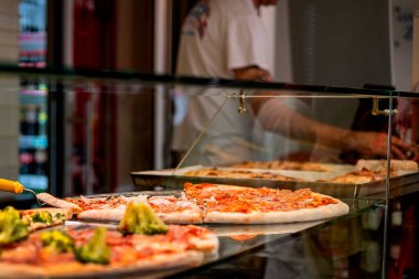 Tezgahta dilimlenmiş büyük pizza, İtalyan sokak tarzı..