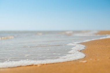 Kumsaldaki kumlara ve mavi yaz gökyüzüne yakın. Panoramik plaj manzarası. Boş tropik plaj ve deniz manzarası