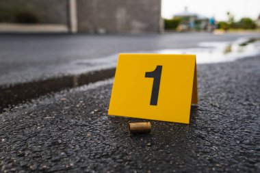 9 mm 'lik kovanlı pirinç mermi kovanından sonra sokakta sarı bir suç mahalli delili var.