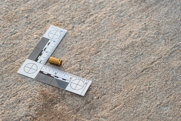 Bir olay yeri kanıt cetveli, 9 mm 'lik kovan ve 9 mm' lik tabanca mermisinden sonra sokaklardaydı.