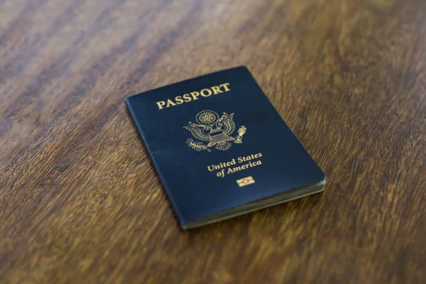 一本蓝色的美国护照放在木制桌子上 — 图库照片